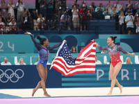 Simone Biles (L) and Sunisa Lee of Team United States celebrate after winning respectively the gold and bronze medal at the end of the Artis...