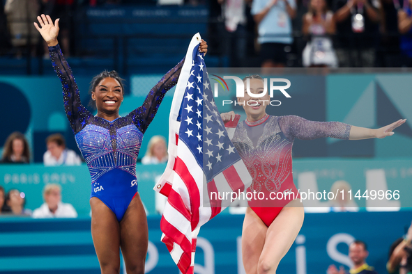 Simone Biles (L) and Sunisa Lee of Team United States celebrate after winning respectively the gold and bronze medal at the end of the Artis...