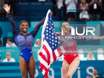 Simone Biles (L) and Sunisa Lee of Team United States celebrate after winning respectively the gold and bronze medal at the end of the Artis...