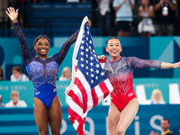 Simone Biles (L) and Sunisa Lee of Team United States celebrate after winning respectively the gold and bronze medal at the end of the Artis...