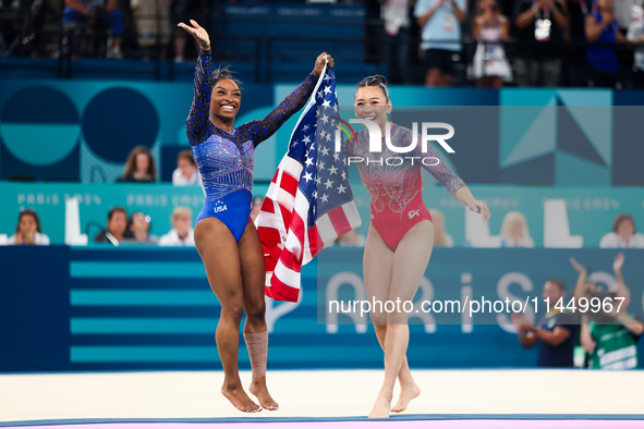 Simone Biles (L) and Sunisa Lee of Team United States celebrate after winning respectively the gold and bronze medal at the end of the Artis...