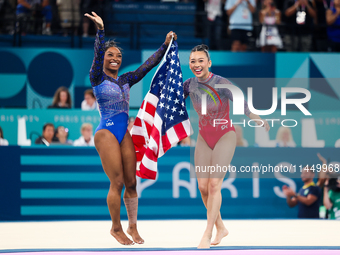 Simone Biles (L) and Sunisa Lee of Team United States celebrate after winning respectively the gold and bronze medal at the end of the Artis...