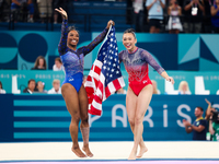 Simone Biles (L) and Sunisa Lee of Team United States celebrate after winning respectively the gold and bronze medal at the end of the Artis...