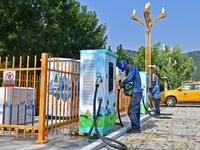 Staff members of the power supply department are checking the operation of electric vehicle charging pile facilities in Dukou village, Yanta...