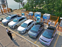 A car owner is using a charging pile to charge an electric vehicle in Dukou village, Yantai, China, on August 2, 2024. (