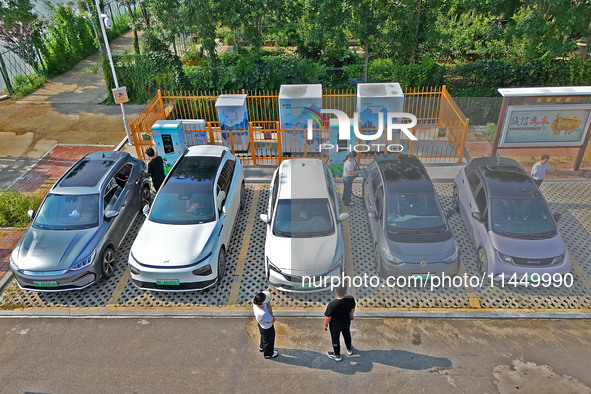 A car owner is using a charging pile to charge an electric vehicle in Dukou village, Yantai, China, on August 2, 2024. 