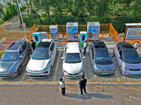 A car owner is using a charging pile to charge an electric vehicle in Dukou village, Yantai, China, on August 2, 2024. (