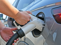 A car owner is using a charging pile to charge an electric vehicle in Dukou village, Yantai, China, on August 2, 2024. (