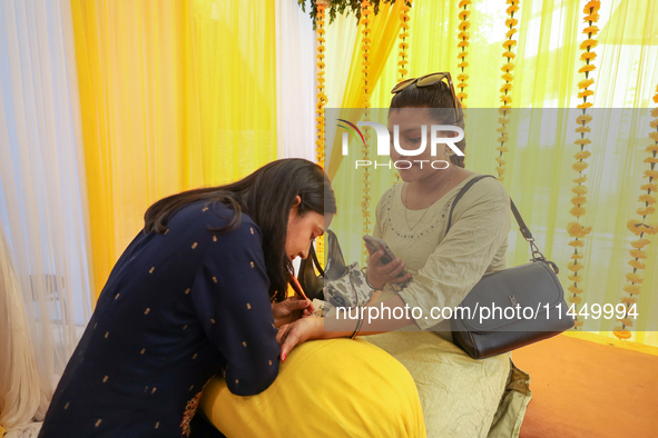 Nepali Hindu women are painting their palms with Heena, commonly called ''mehendi,'' at a fair in Kathmandu, Nepal, on August 2, 2024, as pa...