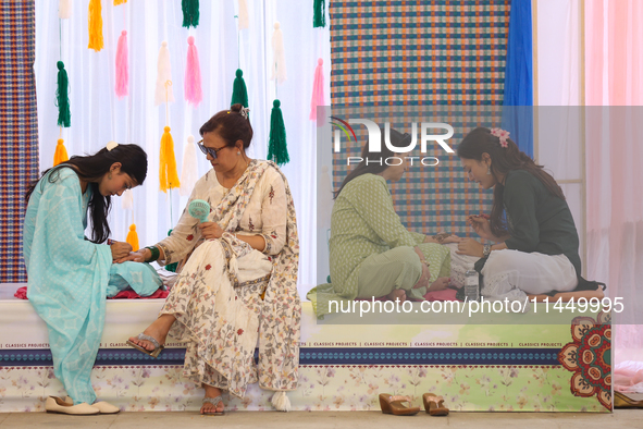 Nepali Hindu women are painting their palms with Heena, commonly called ''mehendi,'' at a fair in Kathmandu, Nepal, on August 2, 2024, as pa...