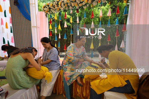 Nepali Hindu women are painting their palms with Heena, commonly called ''mehendi,'' at a fair in Kathmandu, Nepal, on August 2, 2024, as pa...