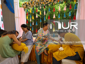 Nepali Hindu women are painting their palms with Heena, commonly called ''mehendi,'' at a fair in Kathmandu, Nepal, on August 2, 2024, as pa...