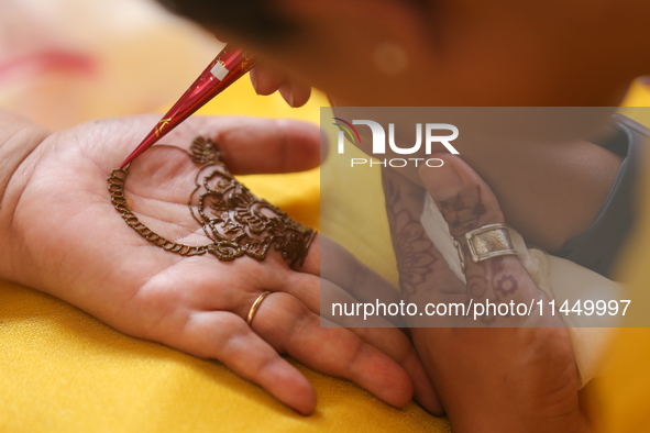 Nepali Hindu women are painting their palms with Heena, commonly called ''mehendi,'' at a fair in Kathmandu, Nepal, on August 2, 2024, as pa...