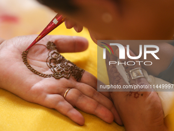 Nepali Hindu women are painting their palms with Heena, commonly called ''mehendi,'' at a fair in Kathmandu, Nepal, on August 2, 2024, as pa...