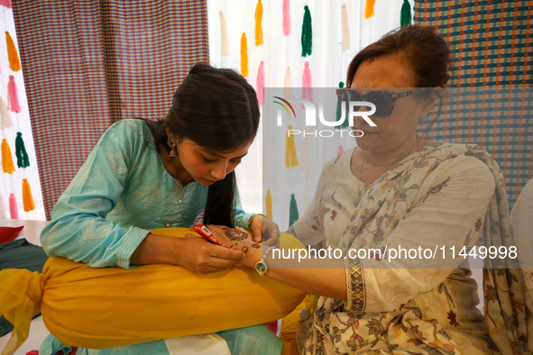 Nepali Hindu women are painting their palms with Heena, commonly called ''mehendi,'' at a fair in Kathmandu, Nepal, on August 2, 2024, as pa...