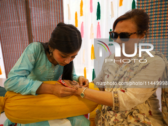 Nepali Hindu women are painting their palms with Heena, commonly called ''mehendi,'' at a fair in Kathmandu, Nepal, on August 2, 2024, as pa...