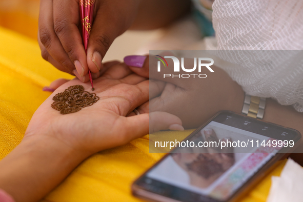 Nepali Hindu women are painting their palms with Heena, commonly called ''mehendi,'' at a fair in Kathmandu, Nepal, on August 2, 2024, as pa...