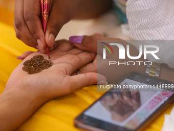 Nepali Hindu women are painting their palms with Heena, commonly called ''mehendi,'' at a fair in Kathmandu, Nepal, on August 2, 2024, as pa...