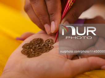 Nepali Hindu women are painting their palms with Heena, commonly called ''mehendi,'' at a fair in Kathmandu, Nepal, on August 2, 2024, as pa...