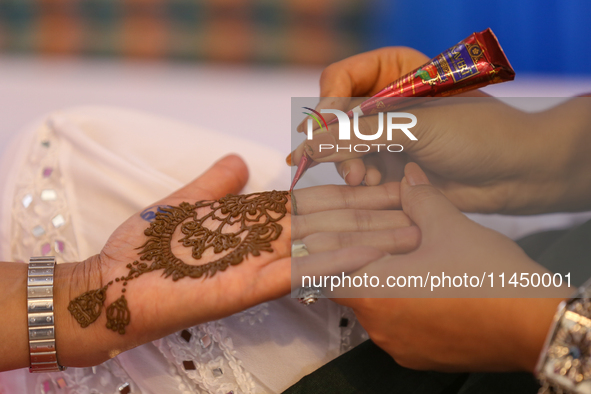 Nepali Hindu women are painting their palms with Heena, commonly called ''mehendi,'' at a fair in Kathmandu, Nepal, on August 2, 2024, as pa...