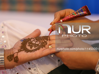 Nepali Hindu women are painting their palms with Heena, commonly called ''mehendi,'' at a fair in Kathmandu, Nepal, on August 2, 2024, as pa...