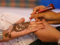 Nepali Hindu women are painting their palms with Heena, commonly called ''mehendi,'' at a fair in Kathmandu, Nepal, on August 2, 2024, as pa...