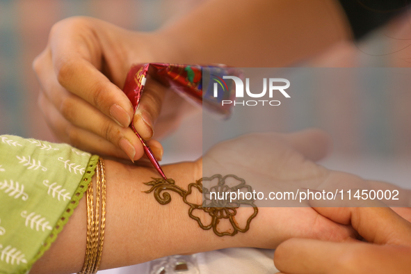 Nepali Hindu women are painting their palms with Heena, commonly called ''mehendi,'' at a fair in Kathmandu, Nepal, on August 2, 2024, as pa...