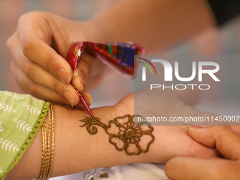 Nepali Hindu women are painting their palms with Heena, commonly called ''mehendi,'' at a fair in Kathmandu, Nepal, on August 2, 2024, as pa...