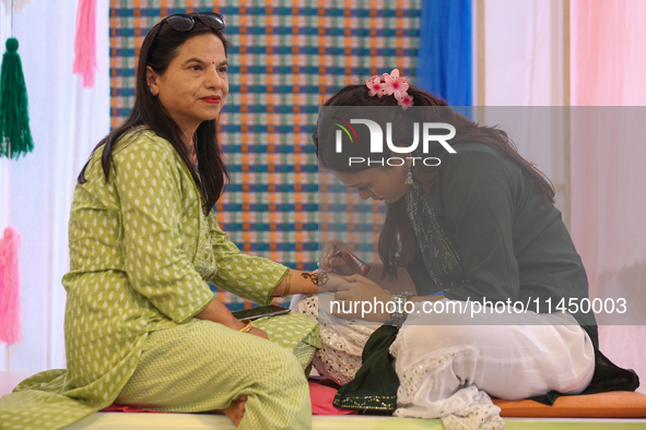 Nepali Hindu women are painting their palms with Heena, commonly called ''mehendi,'' at a fair in Kathmandu, Nepal, on August 2, 2024, as pa...