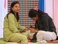 Nepali Hindu women are painting their palms with Heena, commonly called ''mehendi,'' at a fair in Kathmandu, Nepal, on August 2, 2024, as pa...