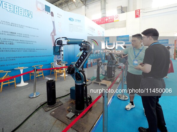 Visitors are visiting a ''resistance welding robot'' at the 13th Beijing International Automobile Manufacturing Expo 2024 in Beijing, China,...