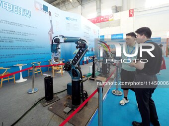 Visitors are visiting a ''resistance welding robot'' at the 13th Beijing International Automobile Manufacturing Expo 2024 in Beijing, China,...