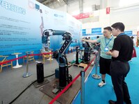 Visitors are visiting a ''resistance welding robot'' at the 13th Beijing International Automobile Manufacturing Expo 2024 in Beijing, China,...