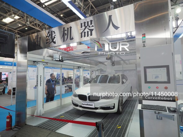 Visitors are visiting a ''curved plate spraying robot'' at the 13th Beijing International Automobile Manufacturing Expo 2024 in Beijing, Chi...