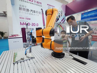 Visitors are visiting a ''six-axis industrial robot'' at the 13th Beijing International Automobile Manufacturing Expo 2024 in Beijing, China...