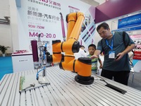 Visitors are visiting a ''six-axis industrial robot'' at the 13th Beijing International Automobile Manufacturing Expo 2024 in Beijing, China...