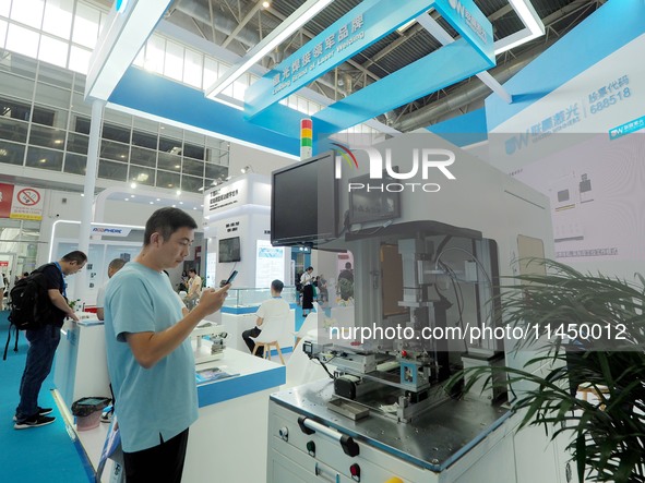 Visitors are visiting a ''laser belt welding machine'' at the 13th Beijing International Automobile Manufacturing Expo 2024 in Beijing, Chin...