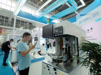 Visitors are visiting a ''laser belt welding machine'' at the 13th Beijing International Automobile Manufacturing Expo 2024 in Beijing, Chin...