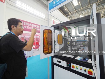 Visitors are visiting a ''CCD visual inspection machine'' at the 13th Beijing International Automobile Manufacturing Expo 2024 in Beijing, C...