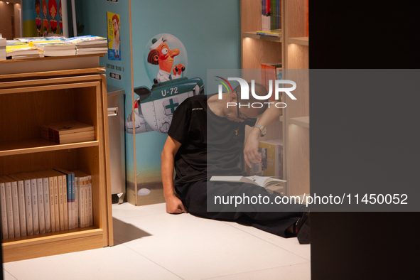 A man is resting on the floor at a bookstore in Shanghai, China, on August 2, 2024, as high temperatures are persisting for the upcoming day...