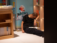 A man is resting on the floor at a bookstore in Shanghai, China, on August 2, 2024, as high temperatures are persisting for the upcoming day...