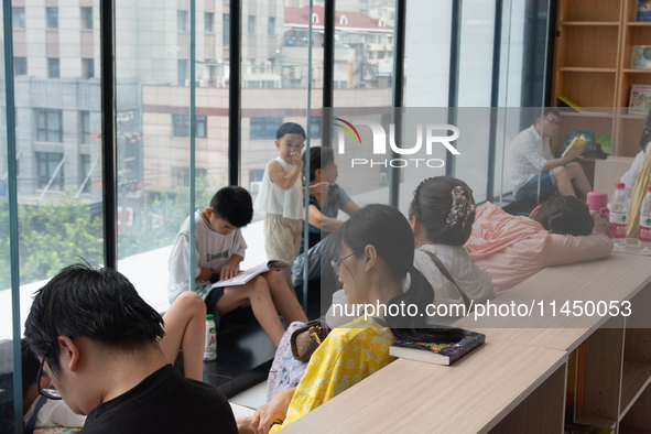 People are resting on the floor at a bookstore in Shanghai, China, on August 2, 2024, as high temperatures are persisting for the upcoming d...