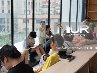 People are resting on the floor at a bookstore in Shanghai, China, on August 2, 2024, as high temperatures are persisting for the upcoming d...