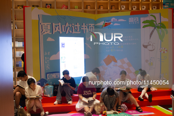 People are resting on the floor at a bookstore in Shanghai, China, on August 2, 2024, as high temperatures are persisting for the upcoming d...