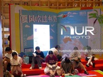 People are resting on the floor at a bookstore in Shanghai, China, on August 2, 2024, as high temperatures are persisting for the upcoming d...