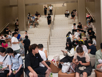 People are resting at a Huawei store in Shanghai, China, on August 2, 2024, as high temperatures are persisting for the upcoming days in Sha...