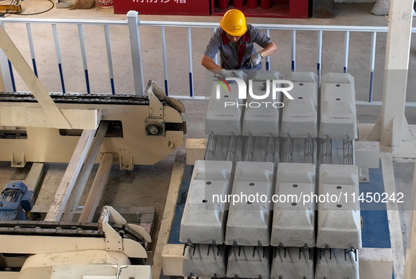 Workers are installing fasteners for a sleeper at the Nanchang-Jiujiang Intercity Railway's Yongrepair sleeper yard in Jiujiang, Jiangxi pro...