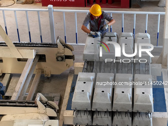 Workers are installing fasteners for a sleeper at the Nanchang-Jiujiang Intercity Railway's Yongrepair sleeper yard in Jiujiang, Jiangxi pro...