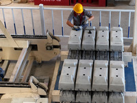 Workers are installing fasteners for a sleeper at the Nanchang-Jiujiang Intercity Railway's Yongrepair sleeper yard in Jiujiang, Jiangxi pro...