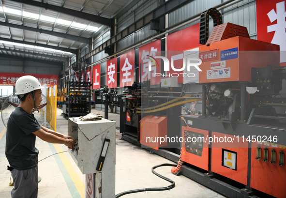 Workers are operating a machine to cast a sleeper at the Nanchang-Jiujiang Intercity Railway's Yongrepair sleeper yard in Jiujiang, China, o...